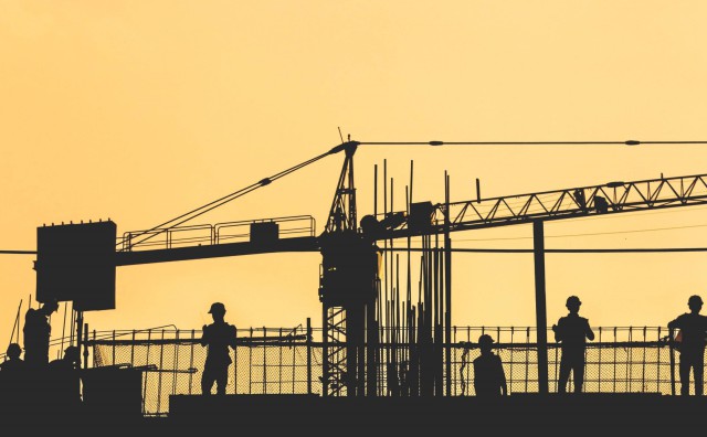 Sun setting behind construction workers